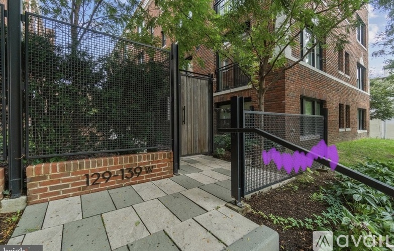 A black metal fence surrounds a brick building entrance.