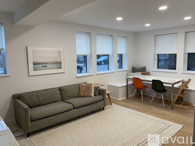 A living room with a grey couch and a white table.