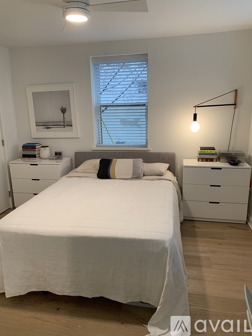 A bedroom with a bed, nightstand, and a lamp.