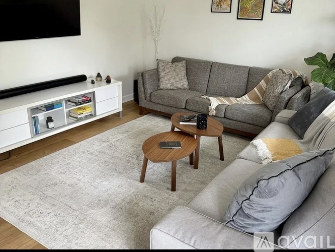 A living room with a grey couch, a coffee table, and a television.