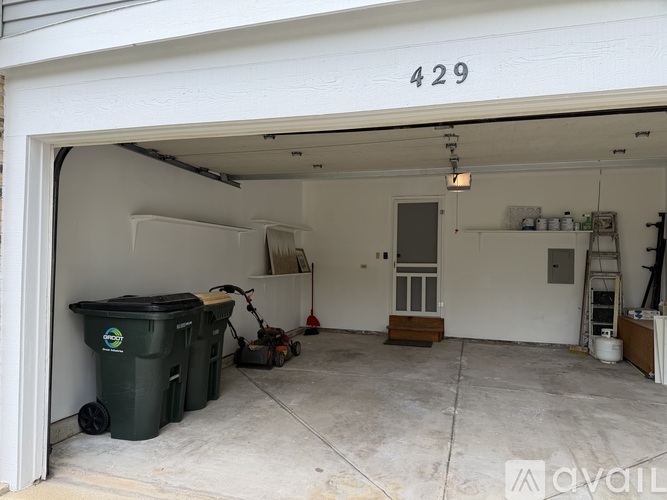 A garage with the number 429 on the wall and a lawnmower inside.