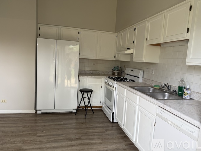 A kitchen with white cabinets and a white fridge.