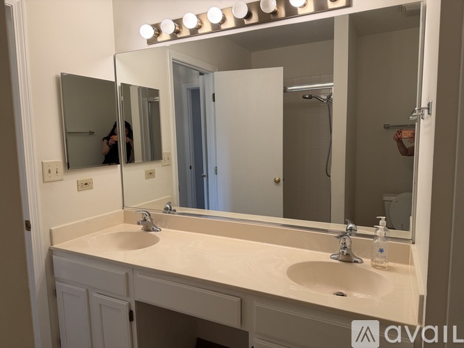 A bathroom with a double sink vanity and a mirror above it.