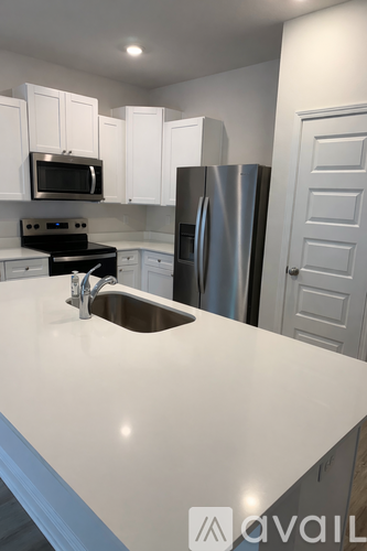 A kitchen with white cabinets and a stainless steel refrigerator.