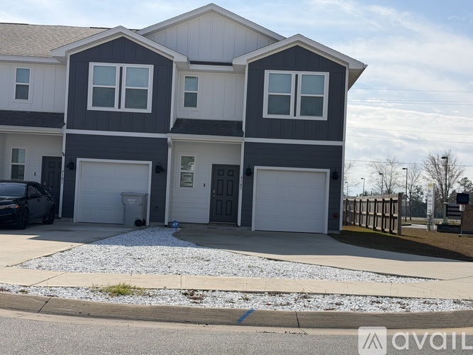 A two-story house with a garage and a driveway.