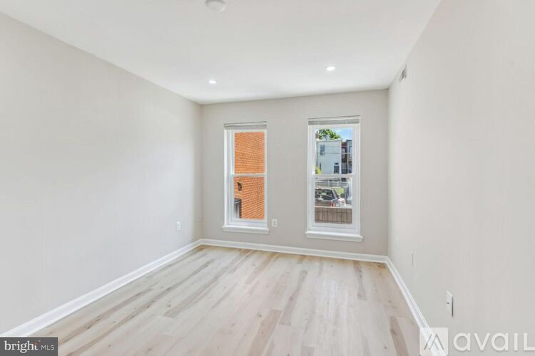 A room with a window and a wooden floor.