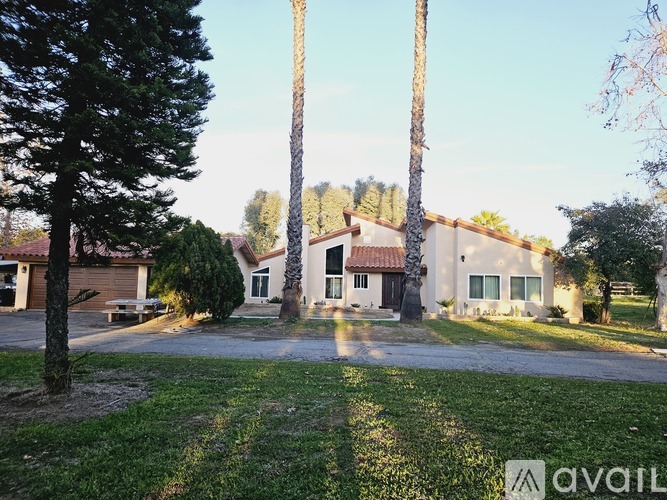 A house with a lawn in front and trees around it.