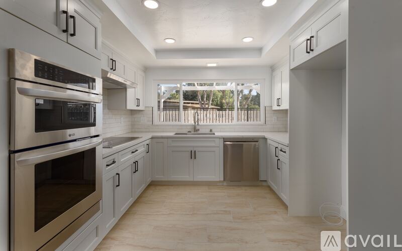 A modern kitchen with stainless steel appliances and white cabinets.