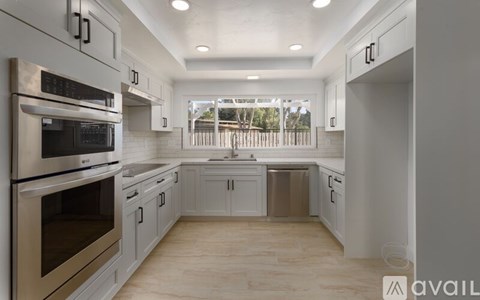A modern kitchen with stainless steel appliances and white cabinets.