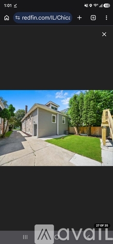 A house with a white fence and green trees in the background.