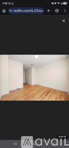 A room with wooden flooring and white walls.