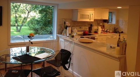 A kitchen with a table and chairs by a window.
