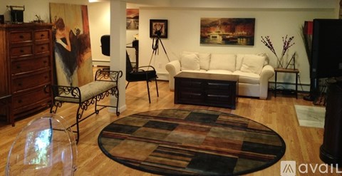 A living room with a white couch and a brown rug.