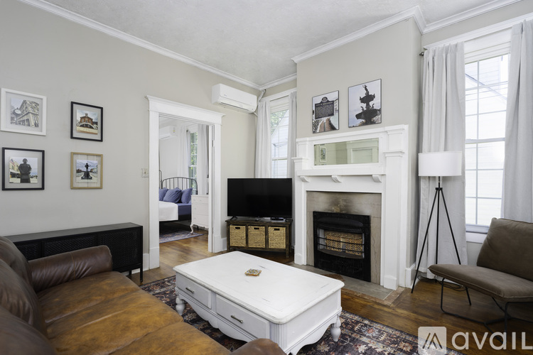 A living room with a fireplace and a brown leather couch.