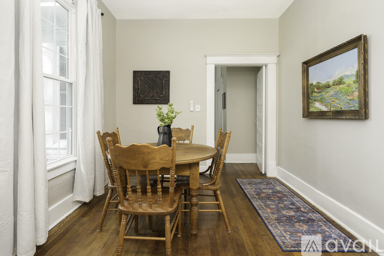 A dining room with a wooden table and chairs.