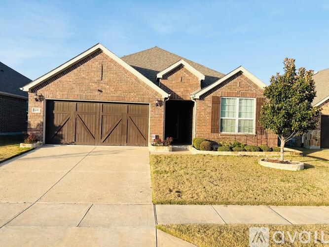A house with a brown garage door and a tree in front.