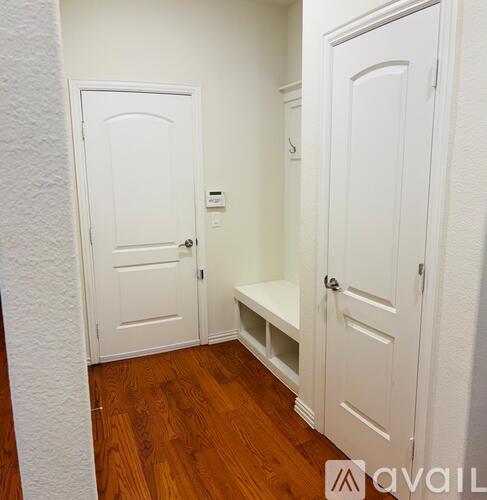 A hallway with a bench and two doors.