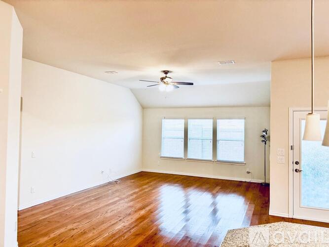 A room with a ceiling fan and a door leading to a balcony.