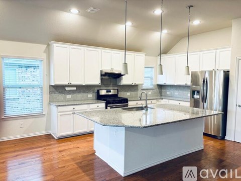 A kitchen with white cabinets and a granite countertop.