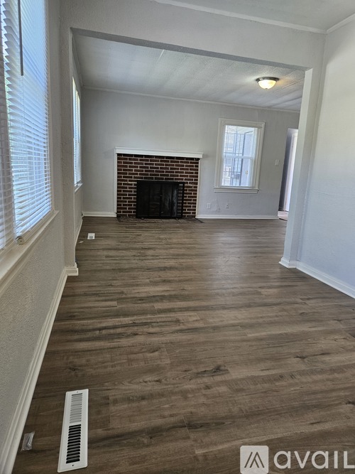A living room with a fireplace and wood flooring.