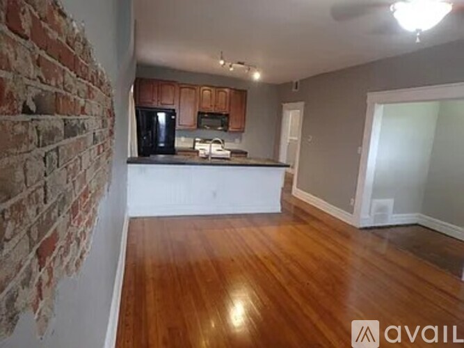 A kitchen with wooden floors and a brick wall.