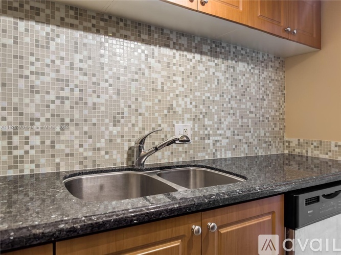 A kitchen with a sink and a tiled backsplash.