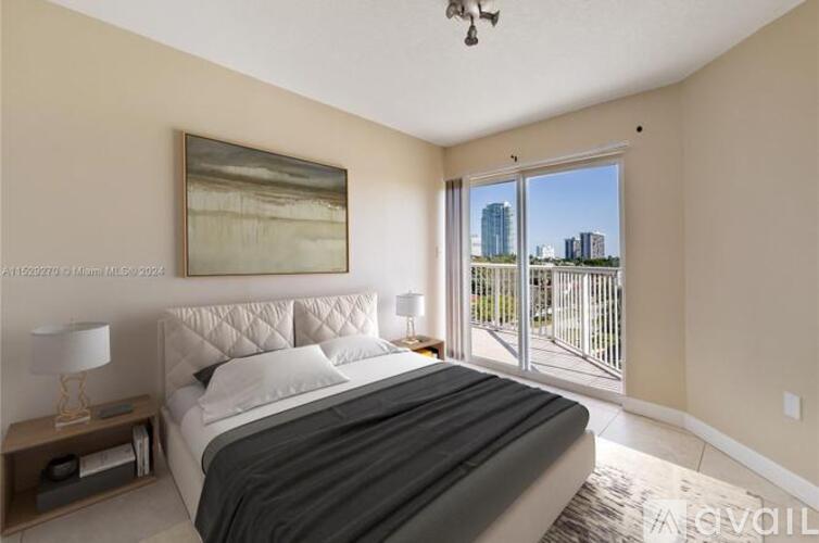 A bedroom with a large bed and a painting on the wall.