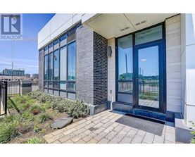 A modern building entrance with a glass door and a brick column.