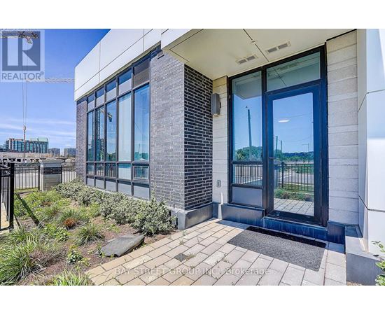 A modern building entrance with a glass door and a brick column.