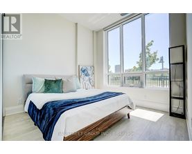 A bedroom with a large bed and a balcony view.