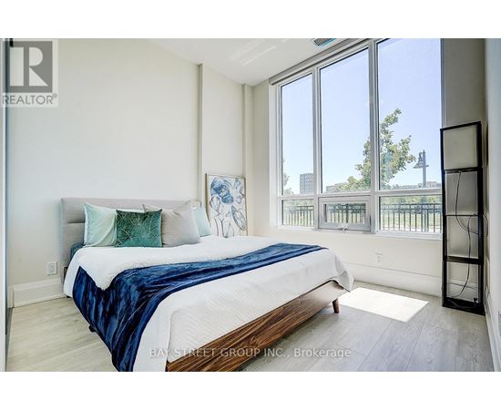 A bedroom with a large bed and a balcony view.