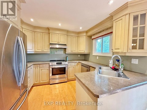 A kitchen with wooden cabinets and a stainless steel refrigerator.