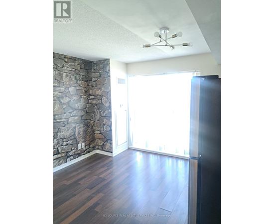 A room with a stone wall and wooden flooring.