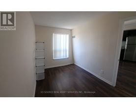 A room with a window and wooden floors.