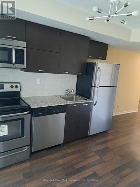 A kitchen with a stainless steel refrigerator and microwave.