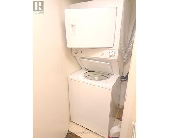 A white toilet with the lid up in a small bathroom.