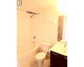 A white toilet sits next to a bathtub in a bathroom.