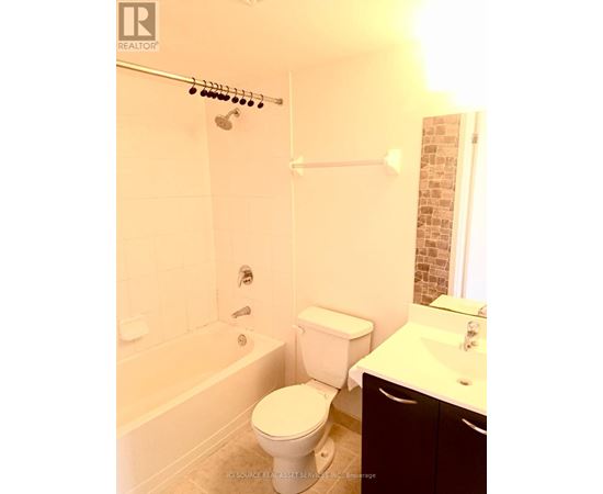 A white toilet sits next to a bathtub in a bathroom.