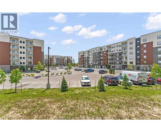 A parking lot with cars and apartment buildings in the background.