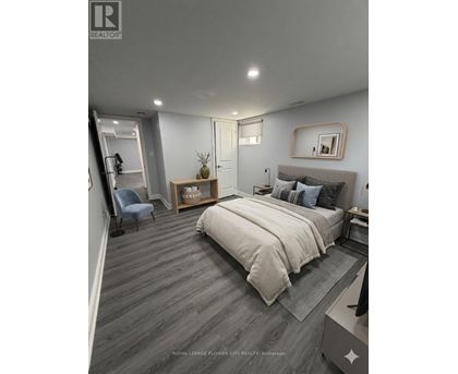 A bedroom with a bed, a chair, and a mirror on the wall.