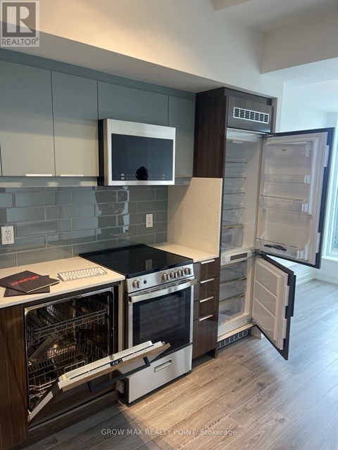 A modern kitchen with a stove, oven, and refrigerator.