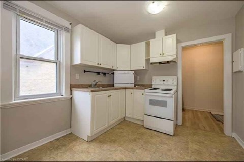 A kitchen with white appliances and cabinets.