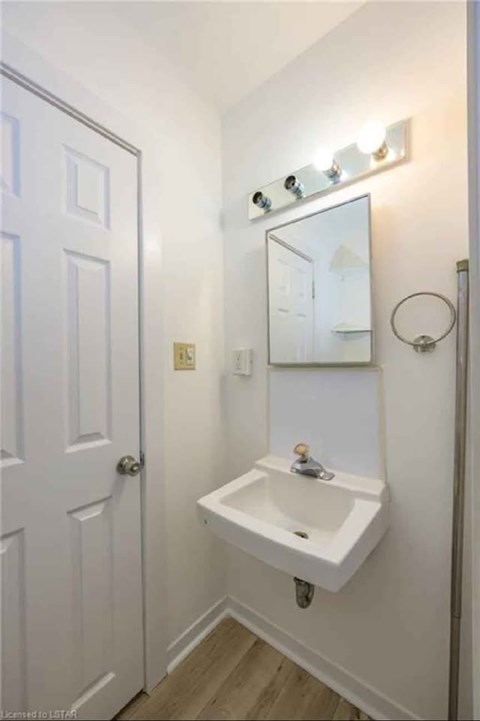 A white bathroom with a sink and mirror.