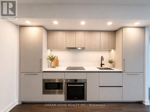 A modern kitchen with a stainless steel oven and microwave.