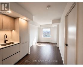 A kitchen with wooden cabinets and a window overlooking a cityscape.