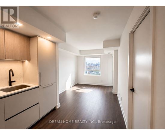A kitchen with wooden cabinets and a window overlooking a cityscape.