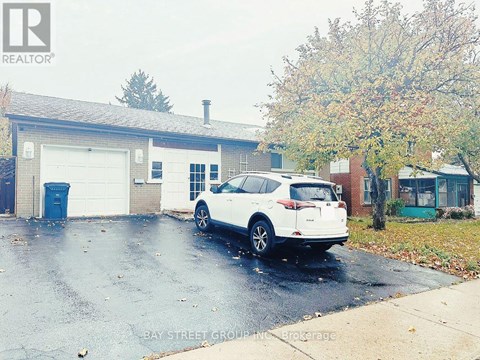 A white car is parked in front of a garage.