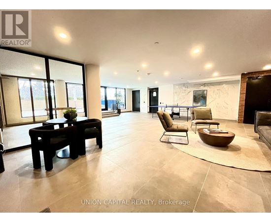 A spacious living room with a black table and chairs.