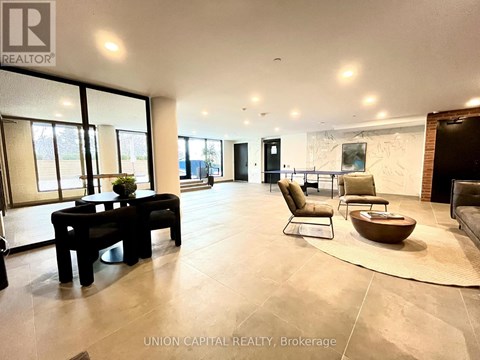 A spacious living room with a black table and chairs.