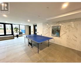 A blue table tennis table in a spacious room with marble walls.